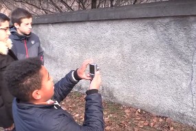 Des collégiens prennent une photo devant un mur
